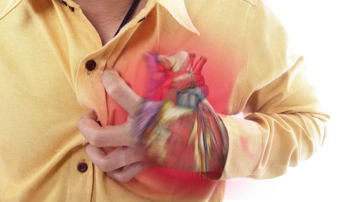 Persona con dolor en el pecho llevándose la mano al corazón durante un infarto de miocardio